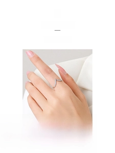 Detail shot of a V-shaped S925 silver ring with blue zircon stones worn on index finger