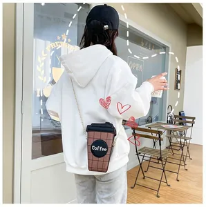 Detailed view of creative coffee cup shaped crossbody bag with metallic chain strap