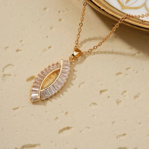 Elegant gold hollow eye necklace with baguette zircons on minimalist stone surface
