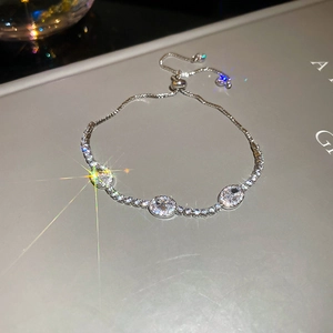 Macro detail of silver tennis bracelet featuring oval cubic zirconia and adjustable slider clasp