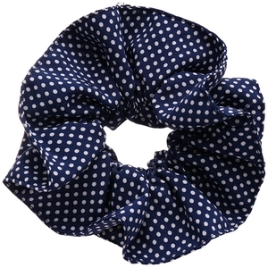 Navy blue fabric scrunchie with white polka dots for ponytail styling on white background