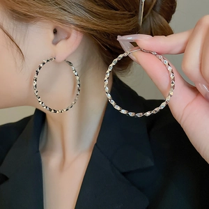 Detailed view of silver geometric hoop earrings with a faceted texture for women