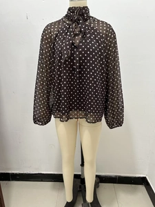 Detailed view of polka dot chiffon shirt featuring a chic neck tie and long sleeves