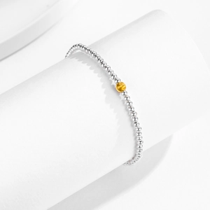 Minimalist s925 silver beaded bracelet with matte gold contrast bead on white pedestal