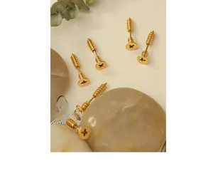 Macro detail of creative gold plated screw shaped stud earrings for a punk hip hop style