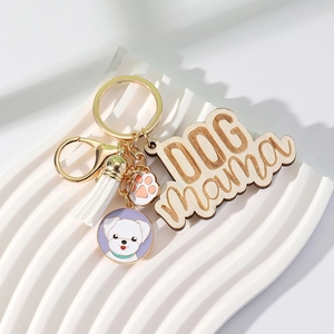 Detail of wooden DOG mama pendant with white tassel and pet enamel charms on gold ring
