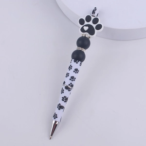 Detail of DIY beaded pen featuring a 3D cat paw charm and printed black plastic body
