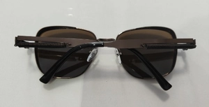 Detail view of steampunk square sunglasses with metal spring hinges and dark lenses