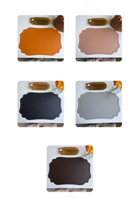 Close-up of faux leather table mats with scalloped edges and retro embossed patterns