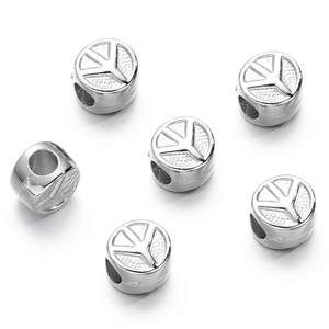 Macro detail of silver CCB plastic cylindrical spacer beads with clover engraved patterns