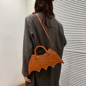 Brown PU leather bat wing crossbody bag with spider web embroidery shown on a model