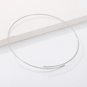 Minimalist silver stainless steel choker necklace on white stone surface