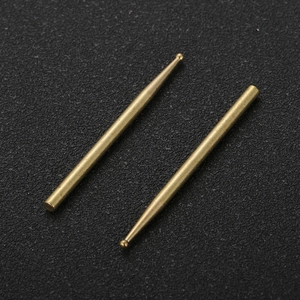 Pair of precision brass locator pins with spherical tips on a black textured background