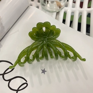 Detail of dark green translucent flower hair claw clip with jelly resin texture