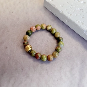 Close-up of 3mm natural unakite stone beads ring with a polished gold accent bead