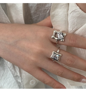 Detailed view of 925 sterling silver rings with square and star cut crystals on hand
