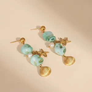 Detailed view of starfish and shell earrings with green natural stones and white pearls