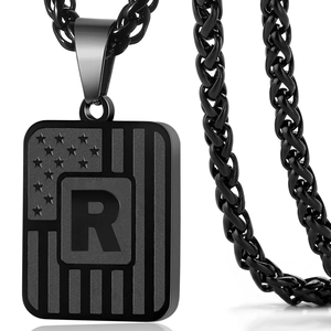 Macro shot of gun-black titanium steel letter R pendant with American flag texture