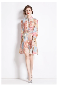 Detail of long sleeve midi dress featuring vibrant paisley prints and waist belt detail