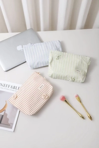 Tre pochette per trucco in tessuto a righe con fiori 3D in blu, verde e rosso