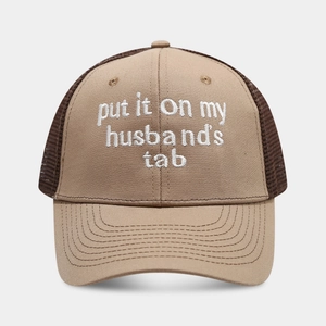 Detailed view of embroidery on breathable mesh trucker hat in khaki and brown colors