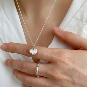 Detail of 925 silver heart necklace with mother of pearl and irregular wave ring set