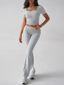 Detail of gray two-piece Y2K crop top and high-waisted flared trousers set on a model
