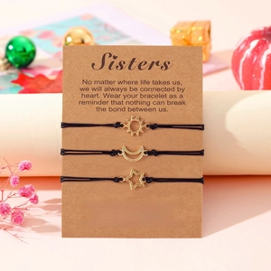 Three-piece sun moon and star friendship bracelets with gold charms on pink gift setting