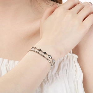 Detailed macro view of a silver double-layered bracelet with polished heart-shaped links