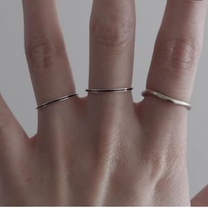 Minimalist 925 sterling silver line rings set featuring sleek wave design on model's hand