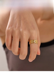 Détail d'une bague ajustable en acier plaqué or 18k avec une texture tressée unique
