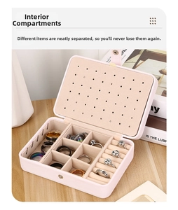 Close-up of pink leather jewelry box with interior compartments and ring slots
