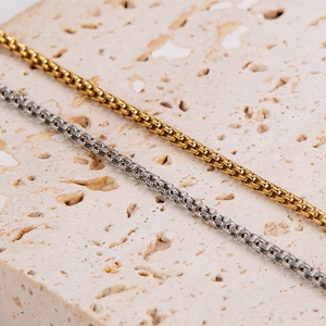 Elegant gold and silver stainless steel box chain bracelets on a natural stone base