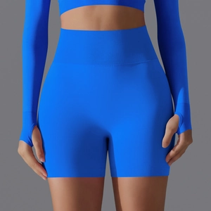 Detailed close-up of ribbed high waistband and seamless knit texture on blue yoga shorts