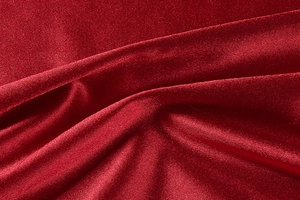Detailed macro view of dark red satin fabric texture with shimmering elegant folds