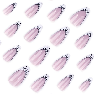French almond press-on nails with white tips, black bows, and polka dot patterns