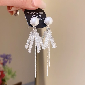 Close-up of tassel earrings with white pearls, crystal beads, and 925 silver chains