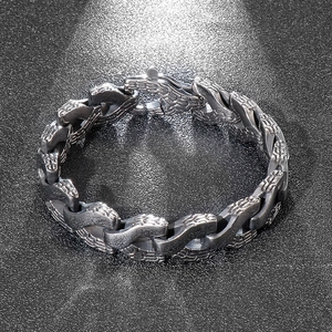 Macro detail of men's titanium steel dragon bone chain bracelet with industrial texture