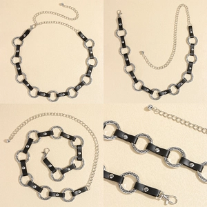 Close-up of black leather waist chain with engraved silver metal rings and rivets