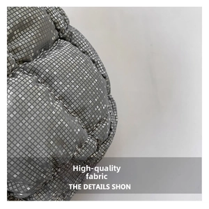 Close-up of silver quilted texture with metallic grid pattern on a cloud handbag