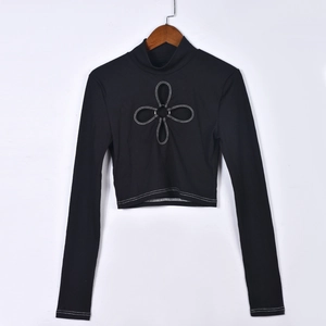 Detail des schwarzen Crop-Tops mit Kleeblatt-Ausschnitt und weißen Kontrastnähten