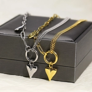 Detailed view of silver and gold titanium steel heart necklaces with polished link chains
