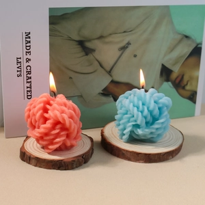 Velas aromáticas creativas con forma de nudo en rosa y azul sobre base de madera