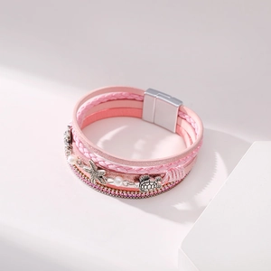 Macro detail of Bohemian multilayer bracelet with pink leather and sea star charms