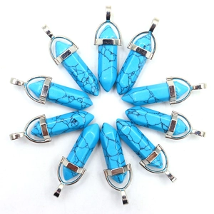 Macro-opname van blauwe turkoois kristallen hangers met zilveren metalen kapjes op witte basis