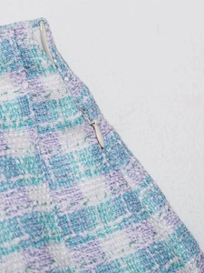 Detail view of the blue tweed skirt set showing a high-quality invisible zipper closure
