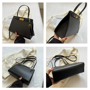 Detail view of black leather tote bag with gold hardware and detachable strap