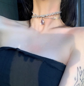 Detail of silver double layer choker with sparkling rhinestones and purple teardrop pendant