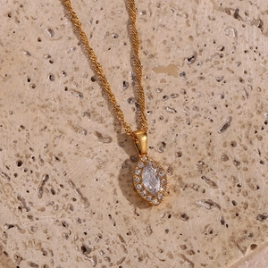 Macro detail of golden marquise cut zircon pendant on natural stone background