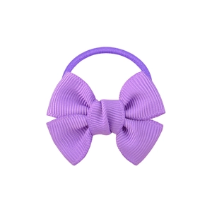 Detail view of a purple bow hair tie made of textured ribbon for kids and women